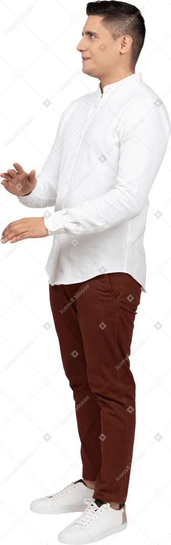 Dreiviertelansicht eines jungen latino-mannes mit leicht erhobenen händen, der verschlagen zur seite schaut