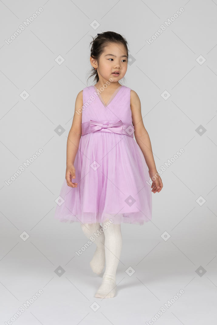 Girl in a pink dress looking aside