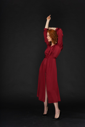 Young ginger lady in red dress posing