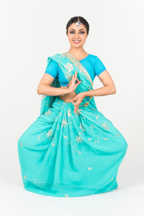 Young indian woman in blue sari standing in dance position