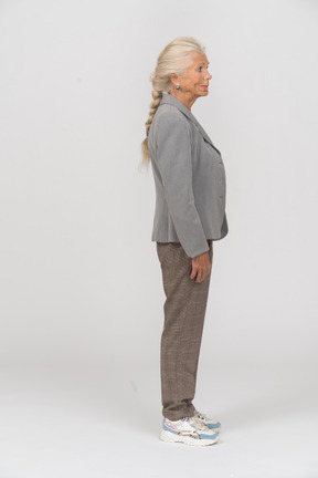 Old woman in grey jacket standing in profile