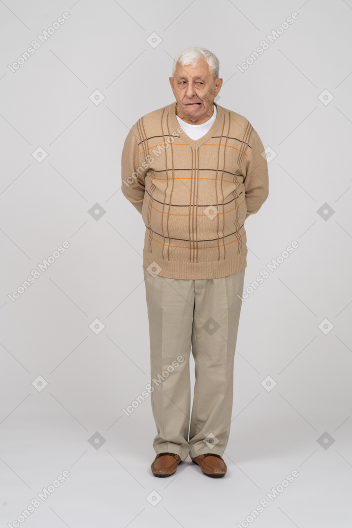 一个穿着休闲服的老人做鬼脸的正面图