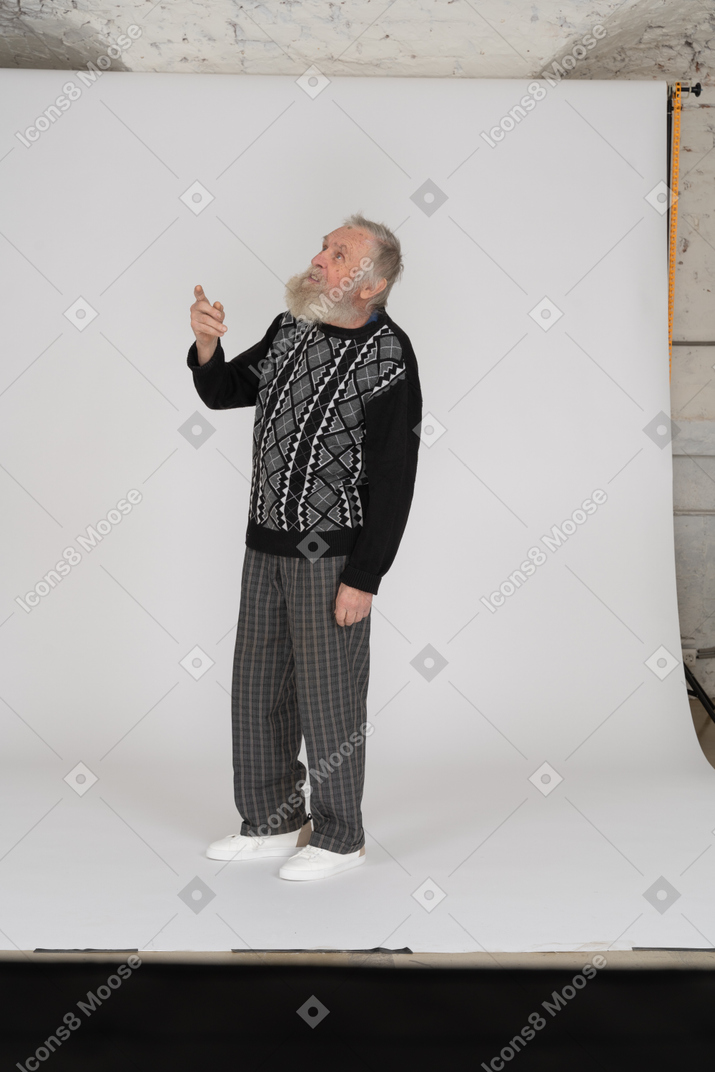 Senior man looking up with raised arm
