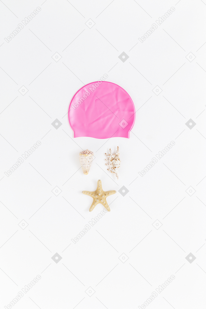 Imitação de rosto feita de conchas e touca rosa