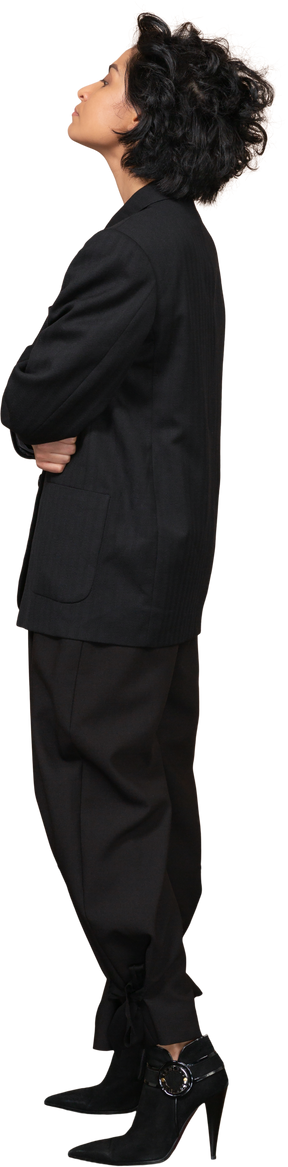 Vista de tres cuartos de una empresaria vestida con traje negro cruzando las manos y echando la cabeza hacia atrás