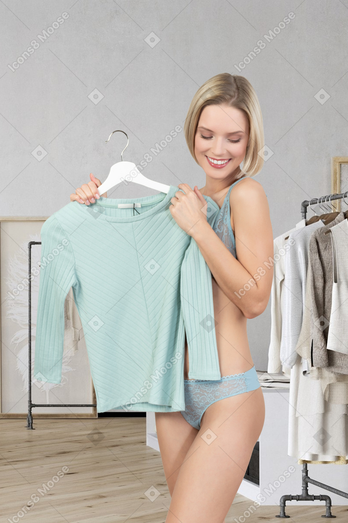 Young woman in underwear getting dressed