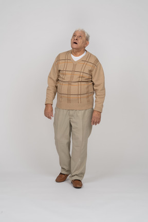 Vista frontal de un anciano impresionado con ropa informal mirando hacia arriba