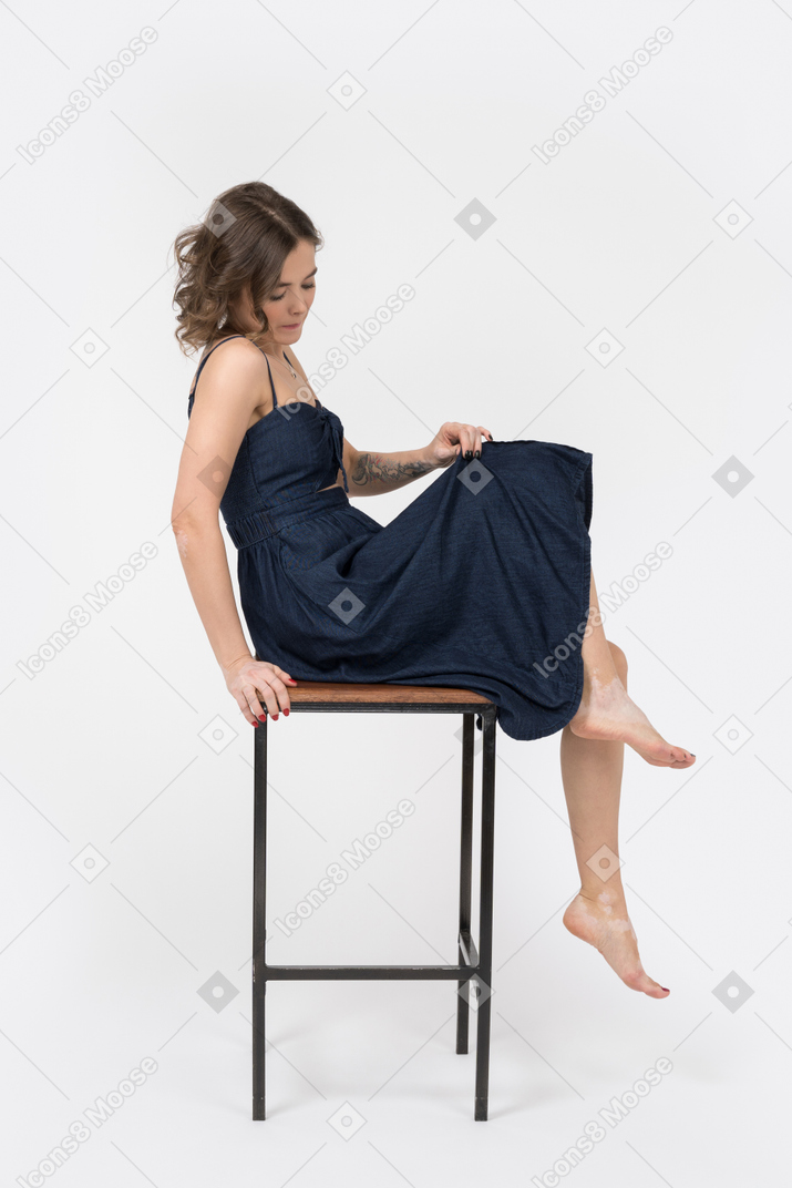 Sensual woman sitting on bar stool in profile