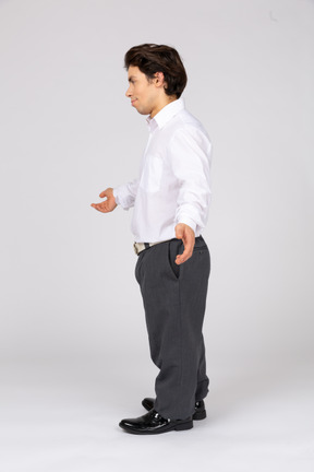 Vista lateral de un hombre con ropa formal levantando las manos