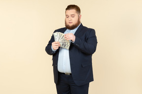 A plus-size man in a black costume with dollar bills in his hands