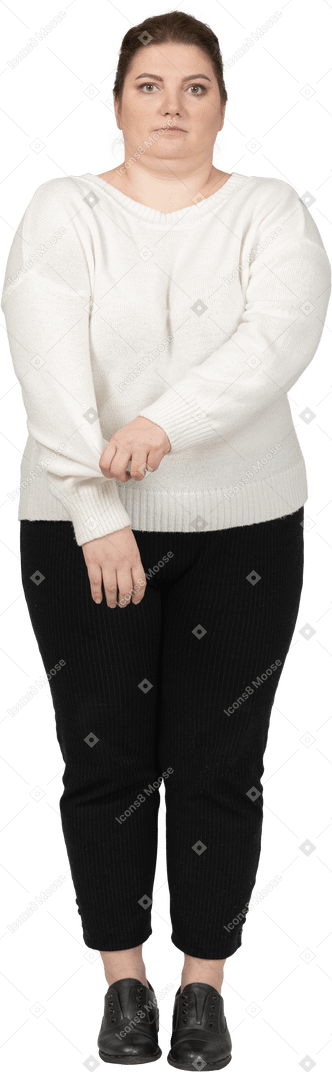 Front view of a plus size woman in casual clothes rolling up her sleeve