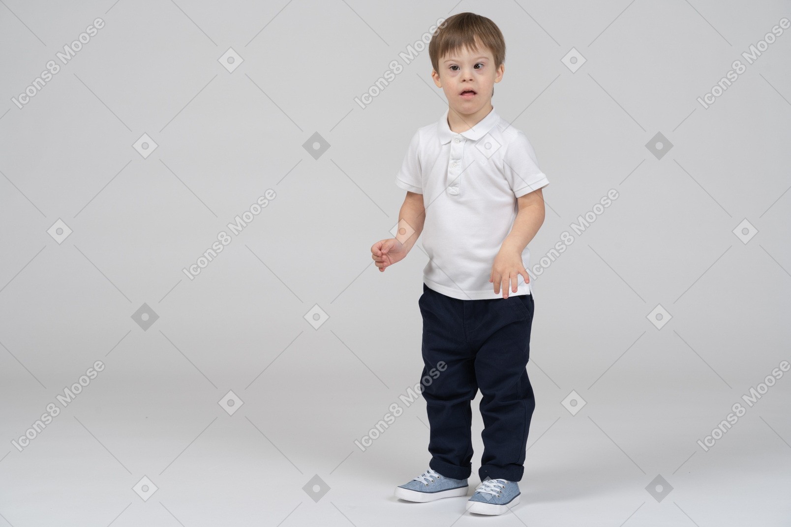 Vista de tres cuartos de un niño de pie sorprendido