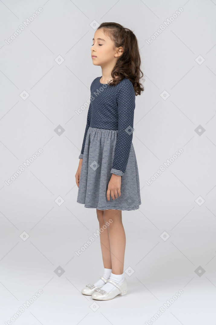 Front view of a girl standing with eyes closed