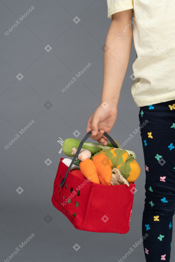 Little girl carrying shopping bag filled with toys