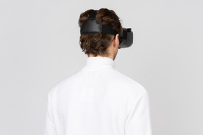 Vista traseira do homem no fone de ouvido de realidade virtual