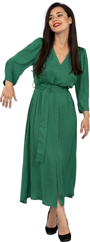 Vista frontal de uma saudação jovem de vestido verde