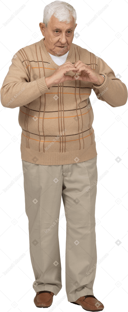 Vista frontal de un anciano con ropa informal haciendo corazón con los dedos