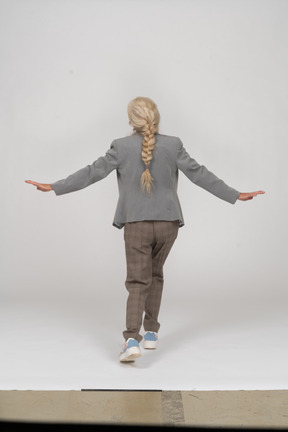 Back view of an old lady in suit outspreading arms