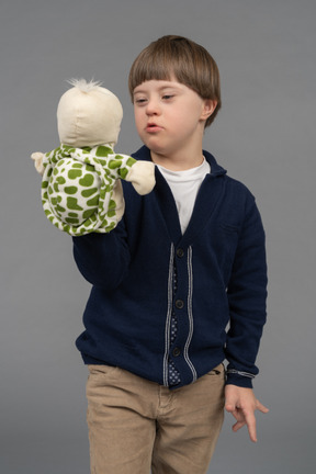 Niño pequeño hablando con una marioneta de tortuga
