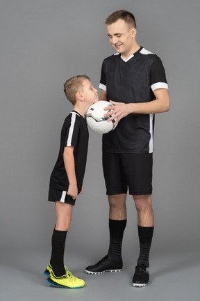 Full-length of a young man coaching little boy