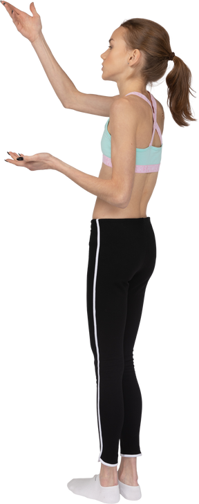 Three-quarter back view of a teen girl in sportswear raising hand and questioning