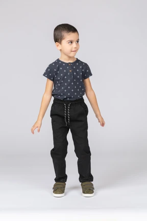 Front view of a cute boy in casual clothes looking aside