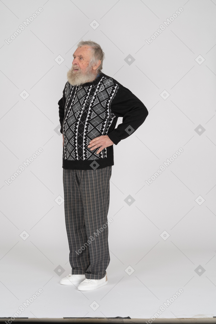 Elderly man with his hands on his hips standing still