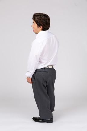 Back view of young man standing with his eyes closed