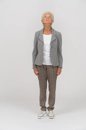 Front view of an old woman in suit looking up
