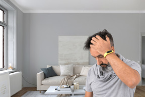 A man holding his head in a living room