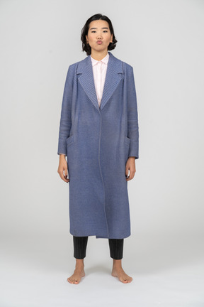 Woman in blue coat with puckered lips