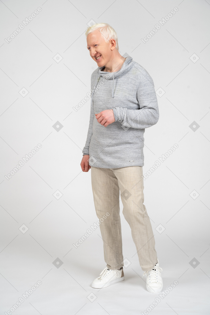 Smiling man standing with his arm bent