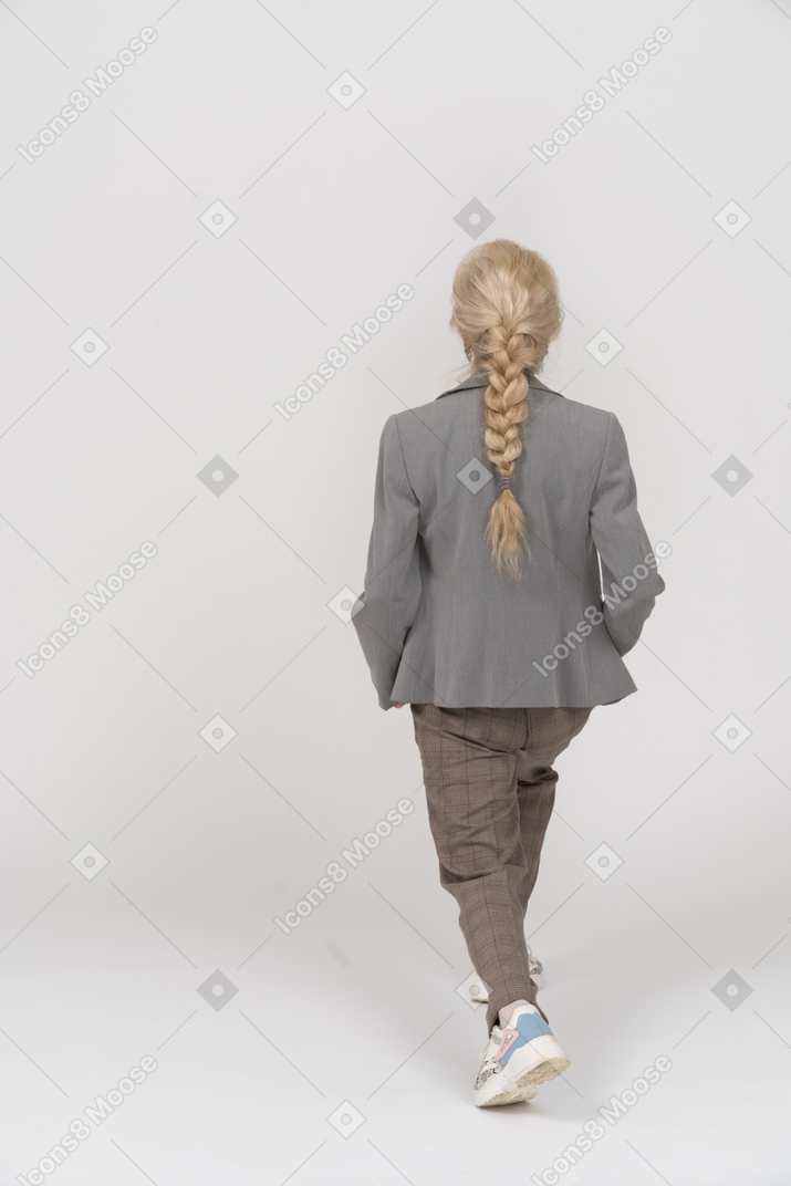 一位身着西装做瑜伽的老妇人的后视图
