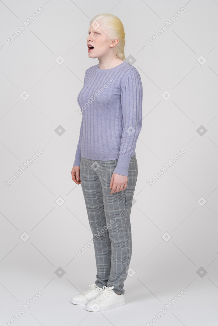 Confused woman in casual clothes standing with arms at sides