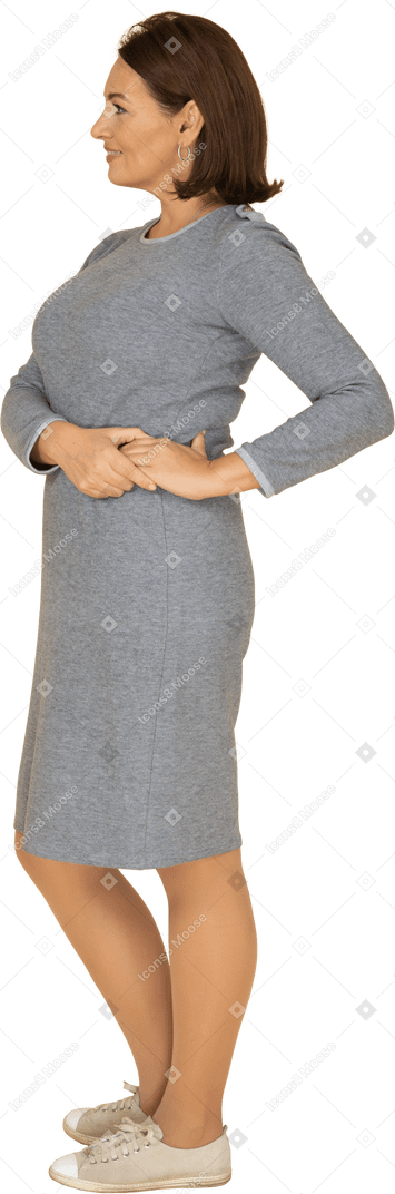 Vista lateral de uma mulher em um vestido cinza posando