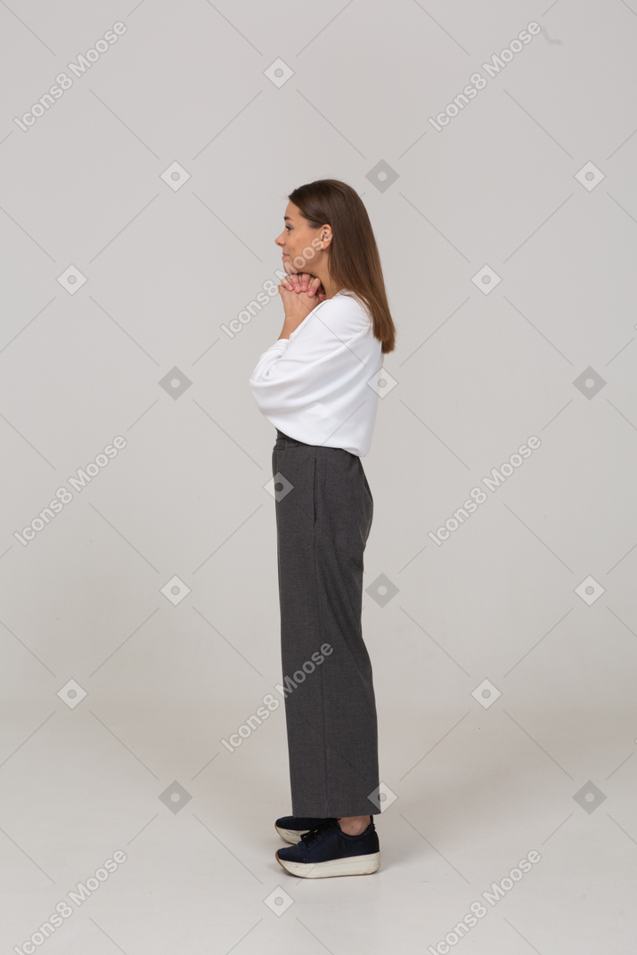 Seitenansicht einer lächelnden jungen dame in bürokleidung, die händchen hält