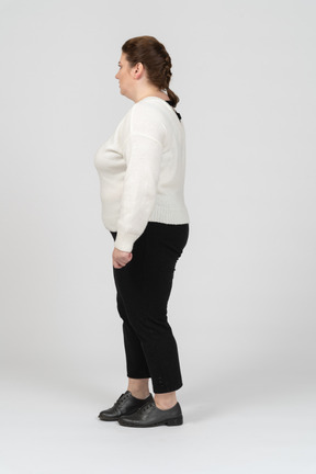 Plus size donna in maglione bianco in piedi di profilo