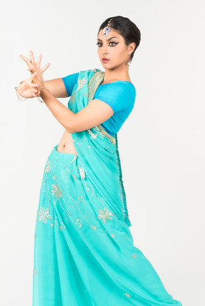 댄스 위치에 서있는 블루 사리에 젊은 인도 여자