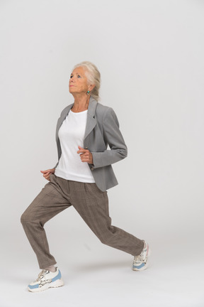 Side view of an old lady in suit doing yoga