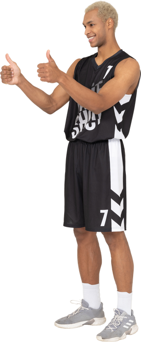 Three-quarter view of a young male basketball player showing thumbs up