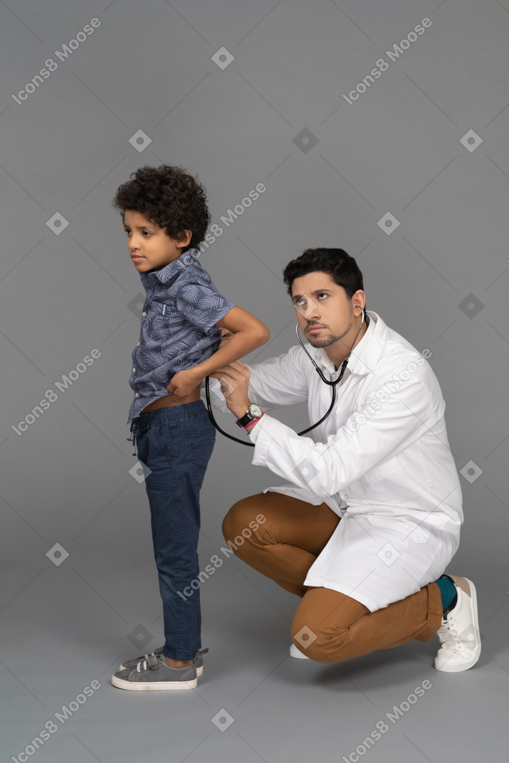어린 소년을 검사하는 의사