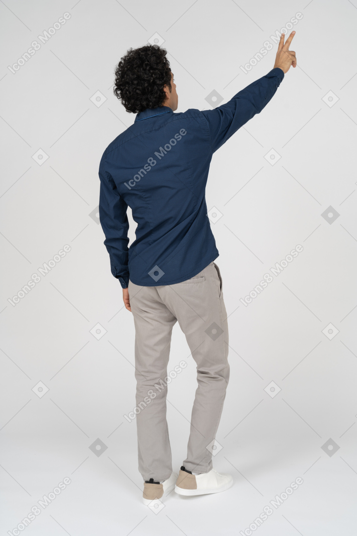 Vサインを示すカジュアルな服装の男性の背面図