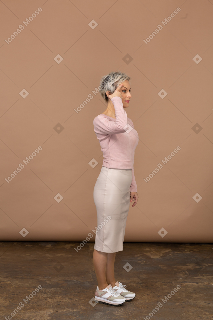 Vista lateral de una mujer en ropa casual tocando la cabeza con el dedo