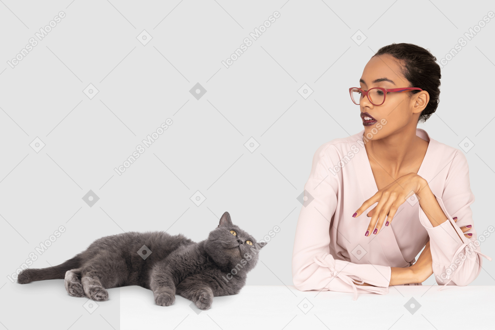 A woman in a pink shirt and a gray cat