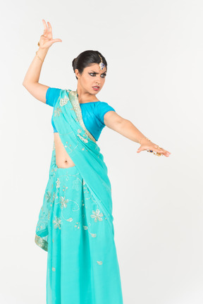 Mad looking young indian dancer standing in dance position