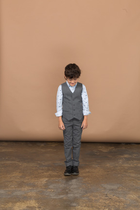 Front view of a boy in suit looking down