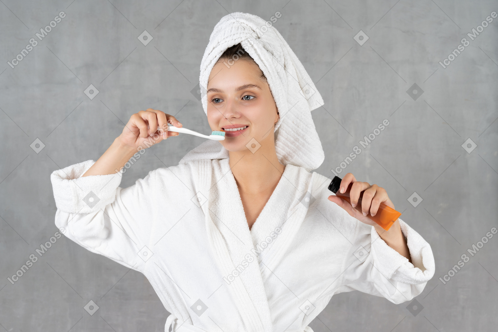 歯磨きをしながら笑顔のバスローブ姿の女性