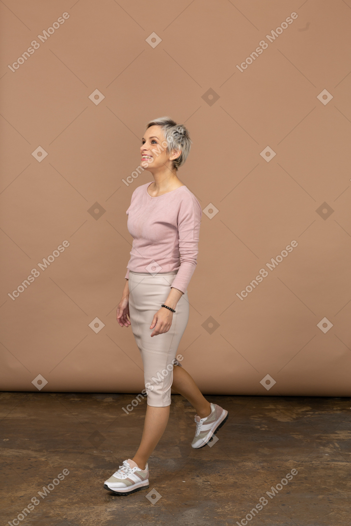 Vue latérale d'une femme en vêtements décontractés marchant
