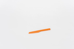 Plastic orange kitchen knife on a white background