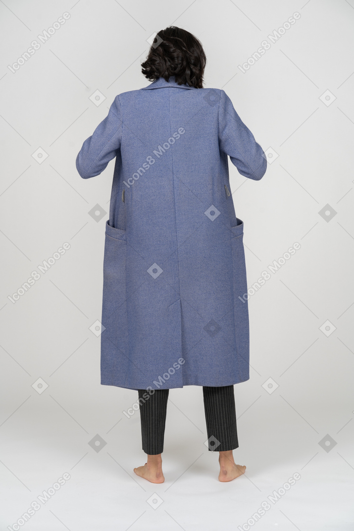 Rear view of a woman adjusting her coat